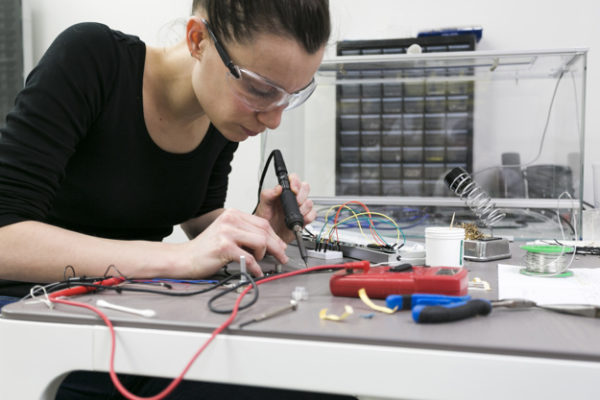 woman-soldering-pieces-at-table_23-2147778873