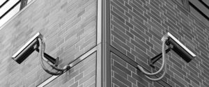 Observation cameras on a building corner in black and white.